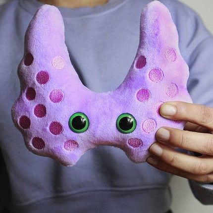 thyroid plushie held by model